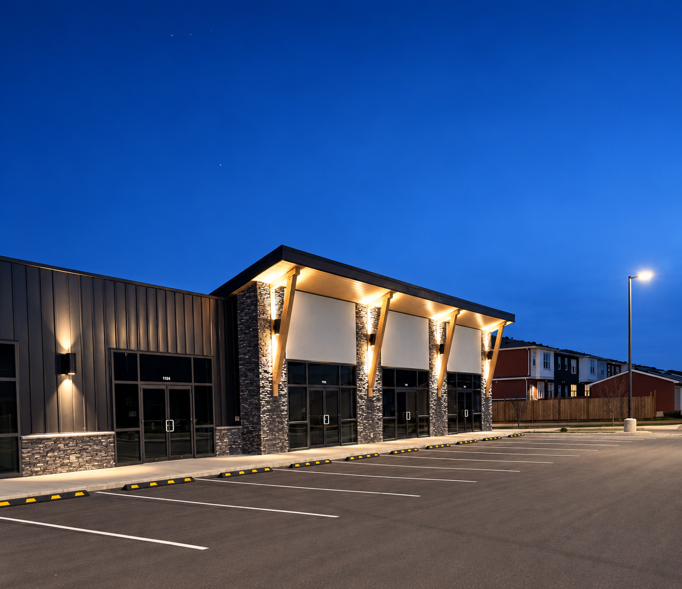Mall storefront and parking-lot lighting at blue hour